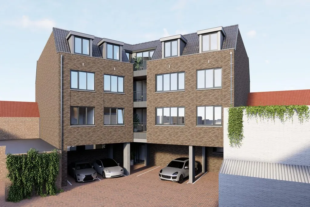 Impressie van de achterzijde van La Licorne met parkeerplaatsen onder het gebouw